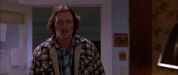 Movie still from “Fire in the Sky” (1993), directed by Robert Lieberman – A man standing in front of a wall in a room; Close Up shot, Low angle