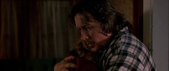 Movie still from “Fire in the Sky” (1993), directed by Robert Lieberman – A person holding a dog; Close Up shot, Over the shoulder angle