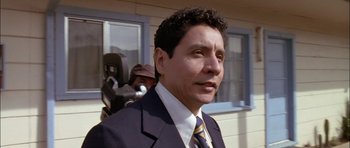 Movie still from “Fire in the Sky” (1993), directed by Robert Lieberman – A person wearing a suit and tie; Close Up shot, Low angle