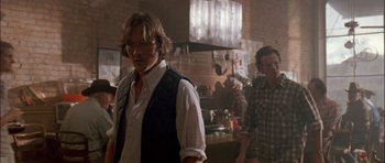 Movie still from “Fire in the Sky” (1993), directed by Robert Lieberman – A man standing in front of another man in a kitchen; Medium shot, Over the shoulder angle
