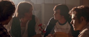 Movie still from “Fire in the Sky” (1993), directed by Robert Lieberman – Two young men sitting at a table talking to each other; Medium shot, Over the shoulder angle