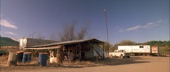 Movie still from “Fire in the Sky” (1993), directed by Robert Lieberman – An rv parked next to a building on the side of the road; Extreme Wide shot, Low angle