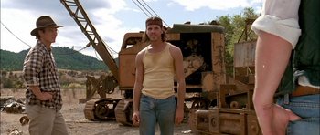 Movie still from “Fire in the Sky” (1993), directed by Robert Lieberman – A man standing in front of a large machine; Medium shot, Low angle
