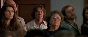 Movie still from “Fire in the Sky” (1993), directed by Robert Lieberman – A man and a woman sitting next to each other in a room; Close Up shot, Over the shoulder angle