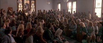 Movie still from “Fire in the Sky” (1993), directed by Robert Lieberman – A large group of people sitting in a room; Wide shot, High angle