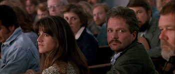 Movie still from “Fire in the Sky” (1993), directed by Robert Lieberman – A group of people sitting in a room; Close Up shot, Over the shoulder angle