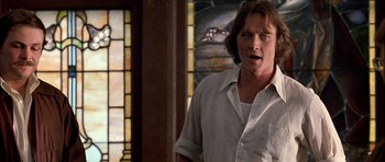 Movie still from “Fire in the Sky” (1993), directed by Robert Lieberman – A man standing in front of a stained glass window; Close Up shot, Low angle
