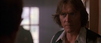 Movie still from “Fire in the Sky” (1993), directed by Robert Lieberman – A person with long brown hair; Close Up shot, Low angle
