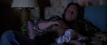 Movie still from “Fire in the Sky” (1993), directed by Robert Lieberman – A man and a child sleeping on a bed; Close Up shot, Over the shoulder angle