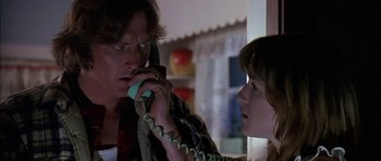 Movie still from “Fire in the Sky” (1993), directed by Robert Lieberman – A man and a woman on the phone in a room; Close Up shot, Low angle