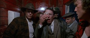 Movie still from “Fire in the Sky” (1993), directed by Robert Lieberman – A group of men standing next to each other in a room; Close Up shot, Low angle