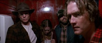 Movie still from “Fire in the Sky” (1993), directed by Robert Lieberman – A group of people standing next to each other on a wall; Close Up shot, Low angle