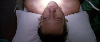 Movie still from “Fire in the Sky” (1993), directed by Robert Lieberman – A man laying in bed with his eyes open; Close Up shot, Overhead angle