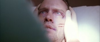 Movie still from “Fire in the Sky” (1993), directed by Robert Lieberman – A person holding his hands up to his face; Extreme Close Up shot, Overhead angle