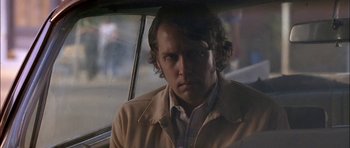 Movie still from “Fire in the Sky” (1993), directed by Robert Lieberman – A man sitting in the back seat of a car; Close Up shot, Over the shoulder angle
