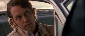 Movie still from “Fire in the Sky” (1993), directed by Robert Lieberman – A man sitting in the back seat of a car; Close Up shot, Low angle