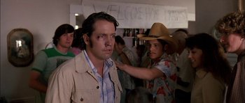 Movie still from “Fire in the Sky” (1993), directed by Robert Lieberman – A man in a cowboy hat is standing next to another man; Close Up shot, Over the shoulder angle