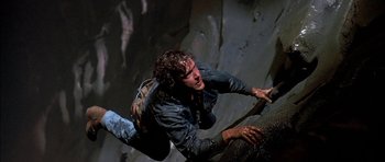 Movie still from “Fire in the Sky” (1993), directed by Robert Lieberman – A man falling off of a cliff while climbing; Medium shot, Overhead angle