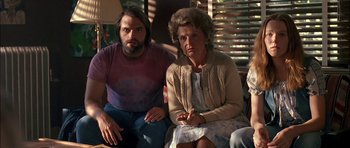 Movie still from “Fire in the Sky” (1993), directed by Robert Lieberman – A man and a woman sitting next to each other on a couch; Medium shot, Low angle