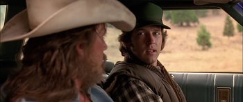 Movie still from “Fire in the Sky” (1993), directed by Robert Lieberman – A man in a cowboy hat sitting next to another man in a cowboy hat; Close Up shot, Over the shoulder angle