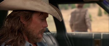 Movie still from “Fire in the Sky” (1993), directed by Robert Lieberman – A man with a cowboy hat sitting in the back of a car; Close Up shot, Over the shoulder angle