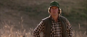 Movie still from “Fire in the Sky” (1993), directed by Robert Lieberman – A man wearing a green hat and a plaid shirt; Close Up shot, Low angle