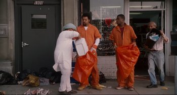 Movie still from “First Sunday” (2008), directed by David E. Talbert – A group of men in orange jumpsuits holding garbage bags; Medium shot, High angle