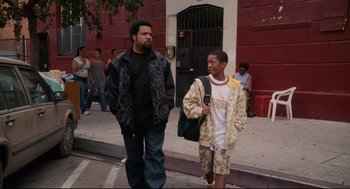 Movie still from “First Sunday” (2008), directed by David E. Talbert – Two men walking down the street one is holding a backpack; Wide shot, High angle