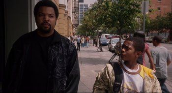 Movie still from “First Sunday” (2008), directed by David E. Talbert – Two men walking down the sidewalk of a city street; Medium shot, Over the shoulder angle