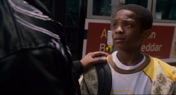 Movie still from “First Sunday” (2008), directed by David E. Talbert – A young man standing next to a person holding a backpack; Close Up shot, Over the shoulder angle