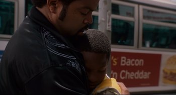 Movie still from “First Sunday” (2008), directed by David E. Talbert – A man is holding a young child in his arms; Close Up shot, High angle