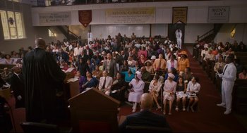 Movie still from “First Sunday” (2008), directed by David E. Talbert – A large group of people sitting in front of a podium; Extreme Wide shot, High angle