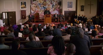 Movie still from “First Sunday” (2008), directed by David E. Talbert – A crowd of people sitting in front of a podium; Extreme Wide shot, High angle