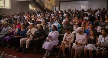 Movie still from “First Sunday” (2008), directed by David E. Talbert – A group of people sitting in a large room; Wide shot, High angle