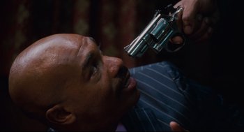 Movie still from “First Sunday” (2008), directed by David E. Talbert – A bald man is holding a gun up to his face; Close Up shot, Overhead angle
