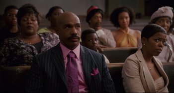 Movie still from “First Sunday” (2008), directed by David E. Talbert – A group of people sitting in front of each other in a room; Medium shot, Low angle