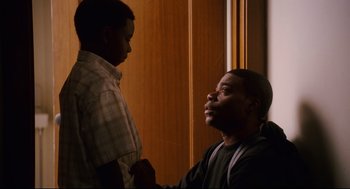 Movie still from “First Sunday” (2008), directed by David E. Talbert – A man and a young boy are talking in a room; Medium shot, Over the shoulder angle
