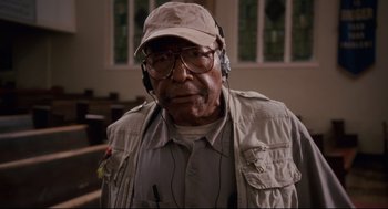 Movie still from “First Sunday” (2008), directed by David E. Talbert – An older man wearing glasses and a hat; Close Up shot, Low angle