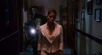 Movie still from “First Sunday” (2008), directed by David E. Talbert – A woman in a white jacket and a man in a green jacket; Medium shot, Low angle