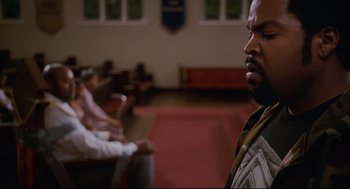 Movie still from “First Sunday” (2008), directed by David E. Talbert – A man standing in front of another man in a room; Close Up shot, Over the shoulder angle