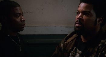 Movie still from “First Sunday” (2008), directed by David E. Talbert – A man and a woman sitting next to each other in front of a wall; Close Up shot, Over the shoulder angle