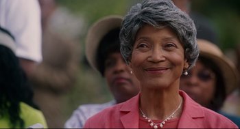 Movie still from “First Sunday” (2008), directed by David E. Talbert – An older woman wearing a hat and a pink jacket; Close Up shot, Over the shoulder angle