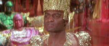 Movie still from “Flash Gordon” (1980), directed by Mike Hodges – A person wearing a gold crown; Close Up shot, Low angle