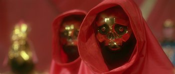 Movie still from “Flash Gordon” (1980), directed by Mike Hodges – A pair of red and gold masks with a skull on them; Close Up shot, Low angle