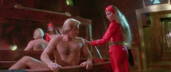 Movie still from “Flash Gordon” (1980), directed by Mike Hodges – A man and a woman in a room with a mirror; Medium shot, Low angle