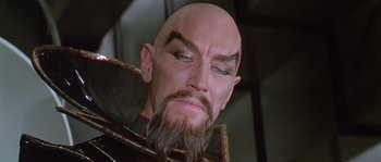 Movie still from “Flash Gordon” (1980), directed by Mike Hodges – The face of a man with a beard; Close Up shot, Over the shoulder angle