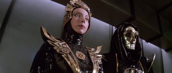 Movie still from “Flash Gordon” (1980), directed by Mike Hodges – A woman wearing a black and gold costume; Close Up shot, Low angle