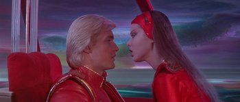 Movie still from “Flash Gordon” (1980), directed by Mike Hodges – A man and a woman dressed in red; Close Up shot, Low angle