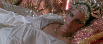 Movie still from “Flash Gordon” (1980), directed by Mike Hodges – A woman wearing a white dress and a gold chain; Close Up shot, High angle