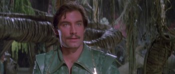 Movie still from “Flash Gordon” (1980), directed by Mike Hodges – A man in a green shirt looking at the camera; Close Up shot, Over the shoulder angle